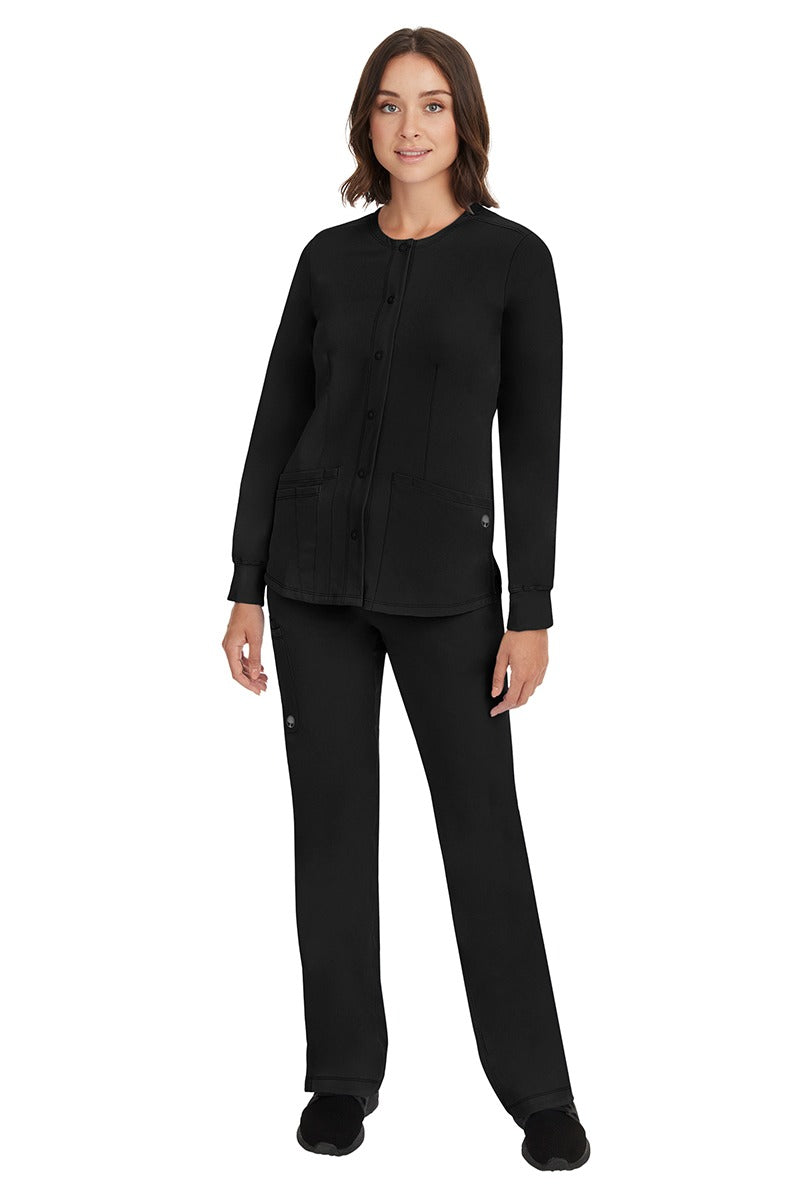 A young female Home Care Registered Nurse wearing an HH-Works Women's Megan Snap Front Scrub Jacket  in Black featuring yoga knit cuffs to ensure a flattering and comfortable fit.
