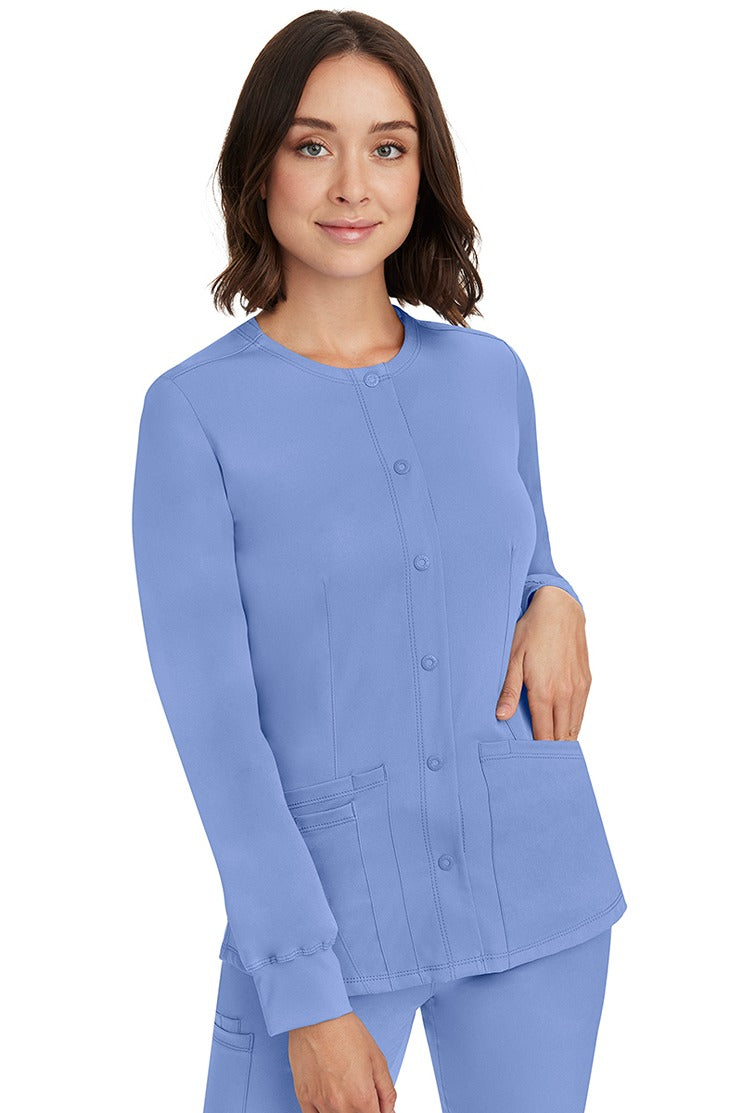 A young lady RN wearing an HH-Works Women's Megan Snap Front Scrub Jacket in Ceil featuring front princess seaming to ensure a flattering fit.