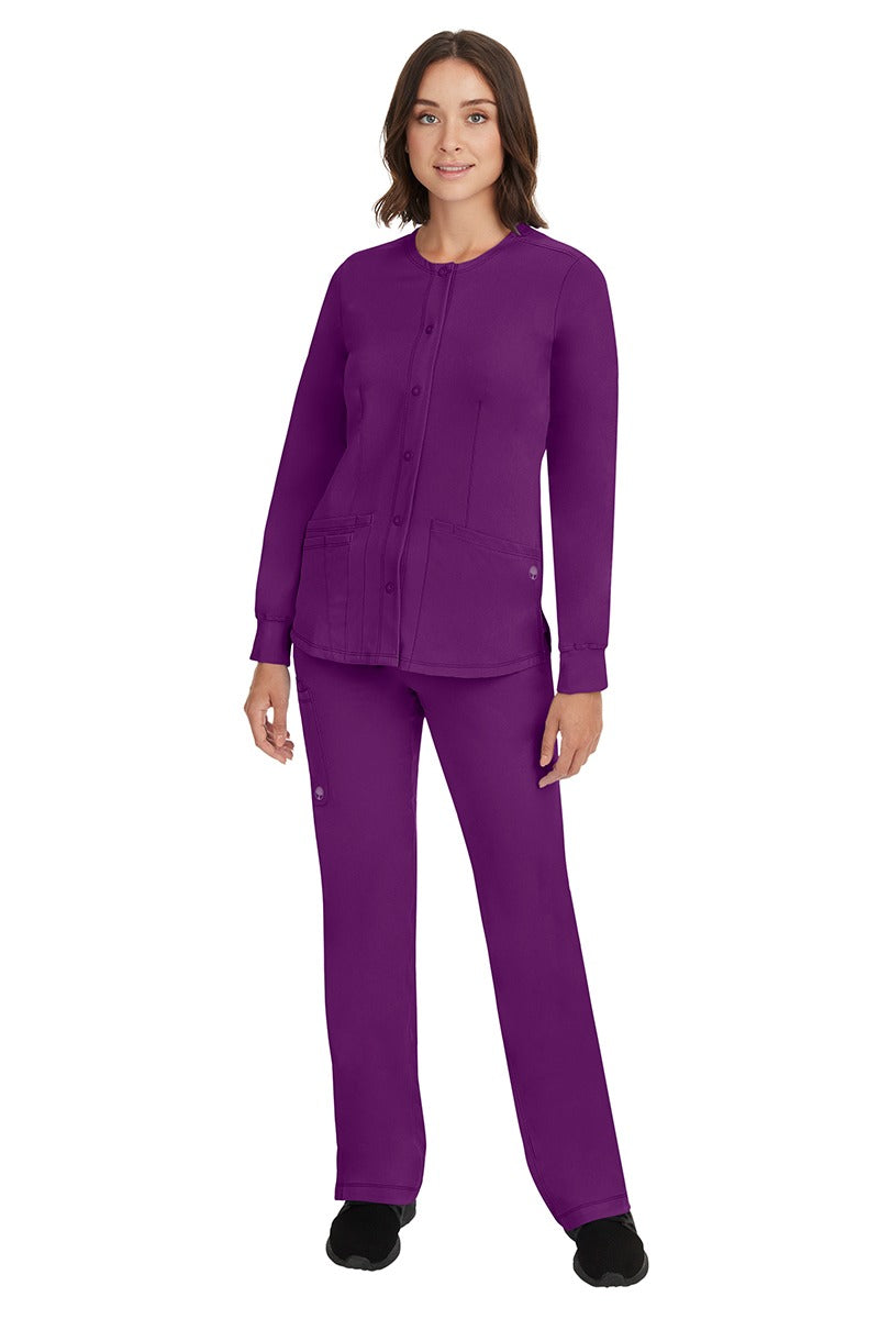 A young female Home Care Registered Nurse wearing an HH-Works Women's Megan Snap Front Scrub Jacket in Eggplant featuring yoga knit cuffs to ensure a flattering and comfortable fit.