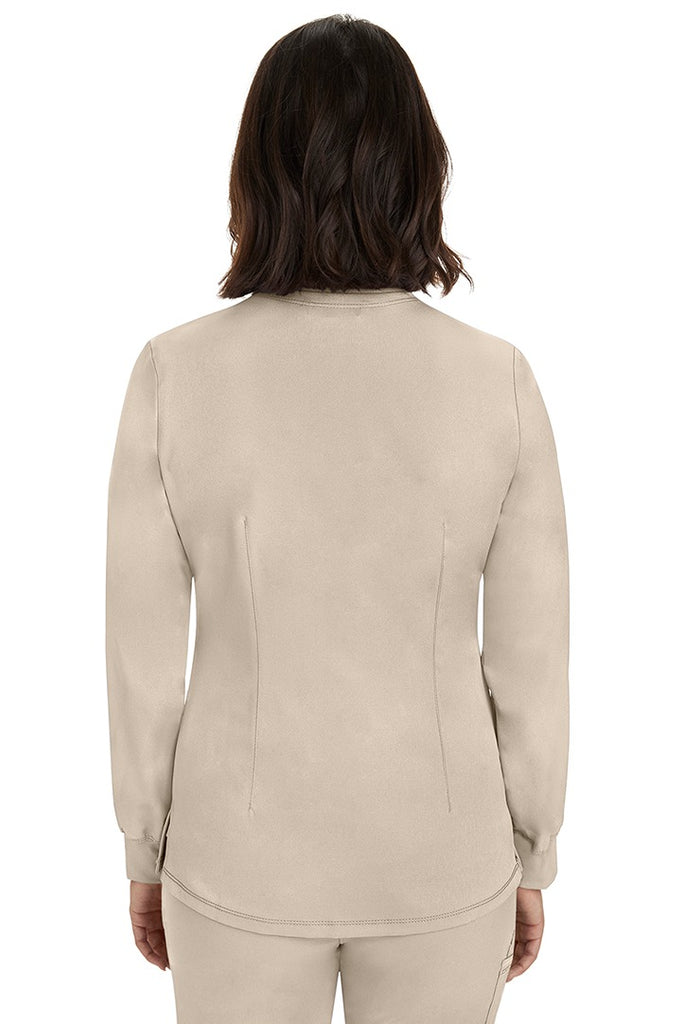 A young female Home Care Registered Nurse wearing an HH-Works Women's Megan Snap Front Scrub Jacket in Khaki featuring a medium center back length of 25.5".