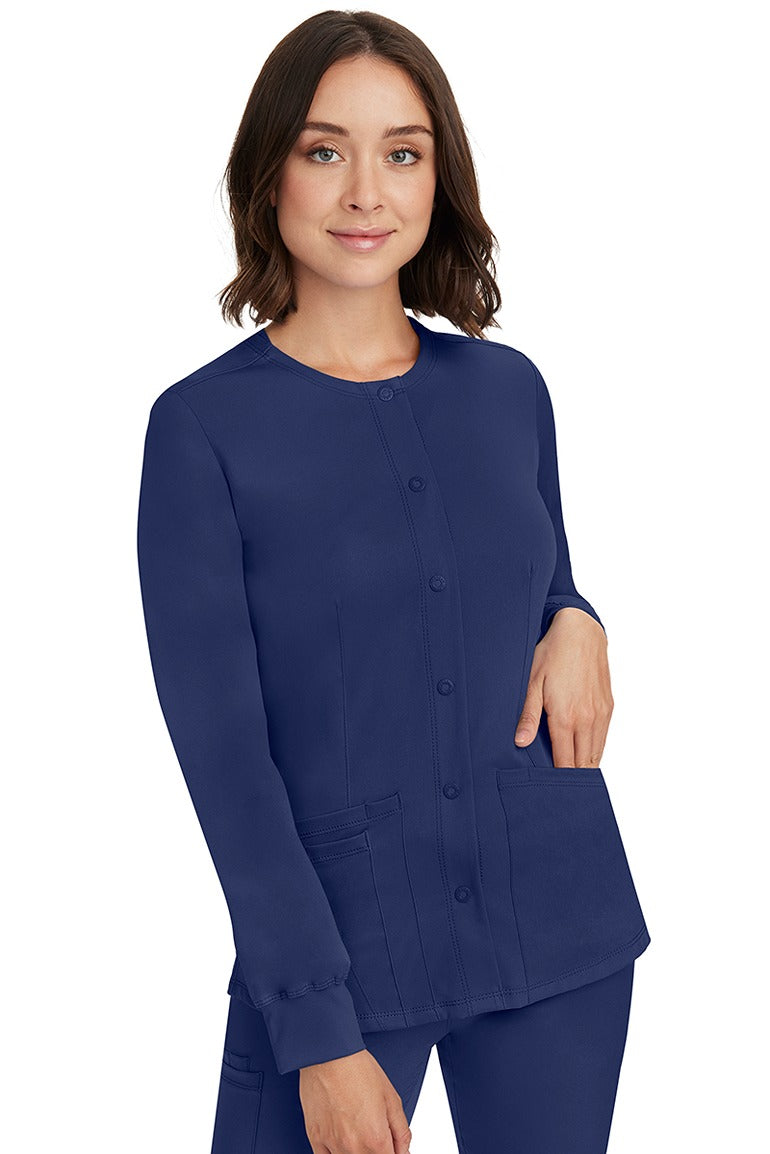 A young lady RN wearing an HH-Works Women's Megan Snap Front Scrub Jacket in Navy featuring front princess seaming to ensure a flattering fit.