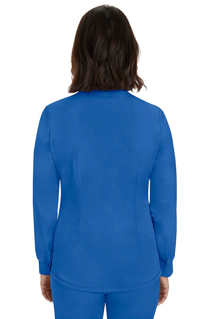 A young female Home Care Registered Nurse wearing an HH-Works Women's Megan Snap Front Scrub Jacket in Royal featuring a medium center back length of 25.5".