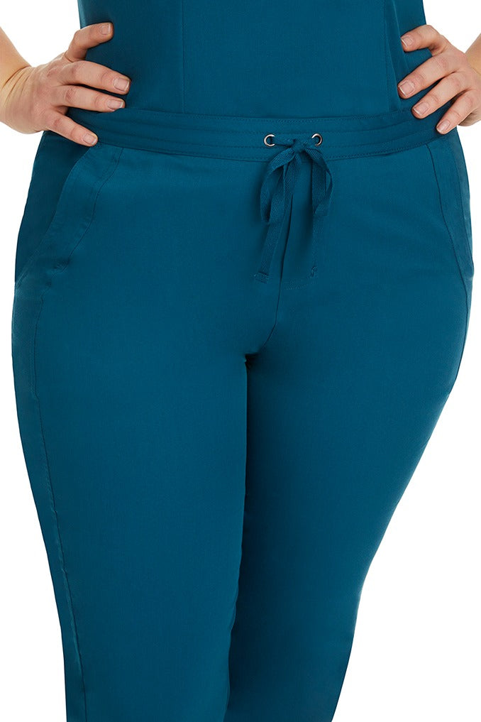 A female healthcare professional wearing a Purple Label Women's Taylor Drawstring Scrub Pant in Caribbean featuring triple needle stitching throughout.