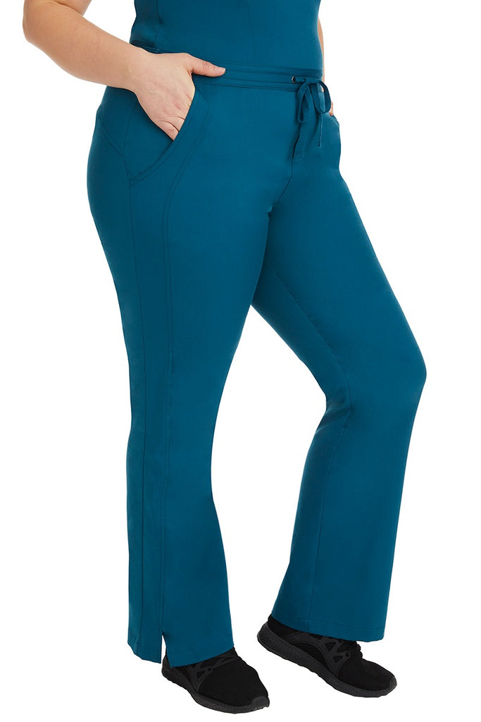 A young female RN wearing the Purple Label Women's Taylor Drawstring Scrub Pant in Caribbean featuring side slits at the ankle for easy slip-on or removal.