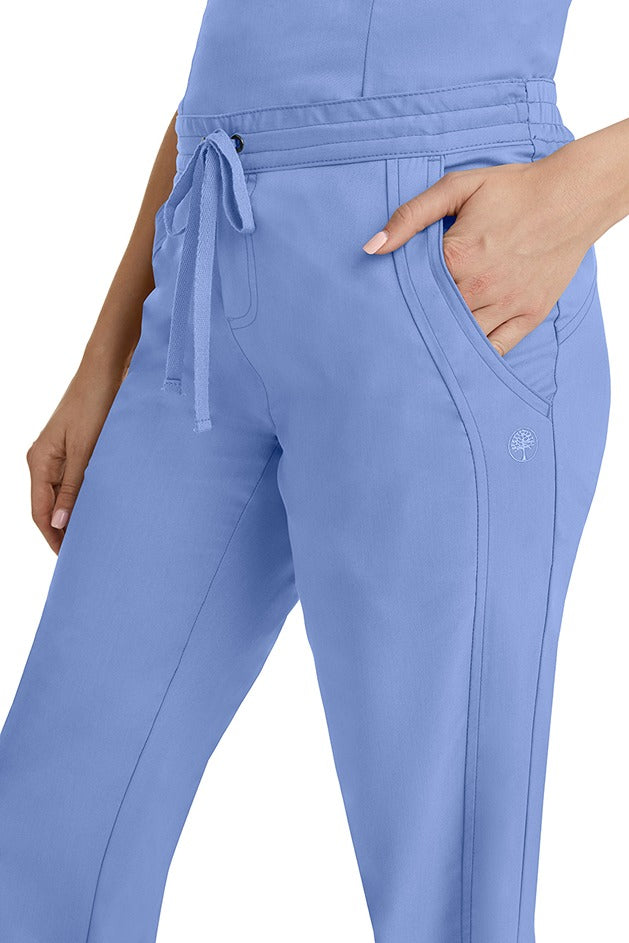 A young woman wearing a pair of Purple Label Women's Taylor Drawstring Scrub Pants from Healing Hands in Ceil. Perfect for Healthcare Professionals working in Hospitals, Doctors offices, Dental Groups & Veterinary offices!