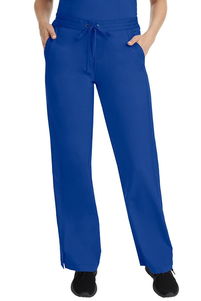 A female LPN wearing a pair of Purple Label Women's Taylor Drawstring Scrub Pants from Healing Hands in Galaxy Blue featuring a front drawstring waist.