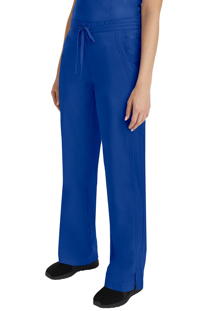 A young Home Care Registered Nurse wearing a Purple Label Women's Taylor Drawstring Scrub Pant in Galaxy Blue featuring front wrap seaming detail throughout.