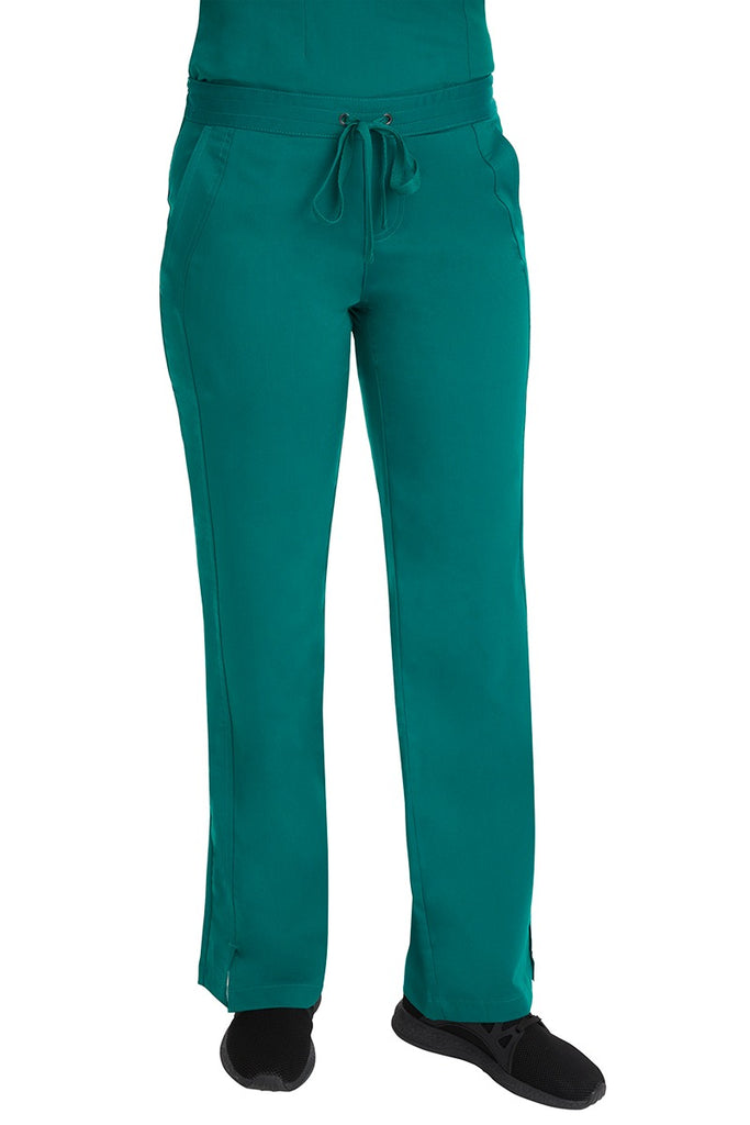 A young Home Care Registered Nurse wearing a Purple Label Women's Taylor Drawstring Scrub Pant in Hunter Green featuring front wrap seaming detail throughout.