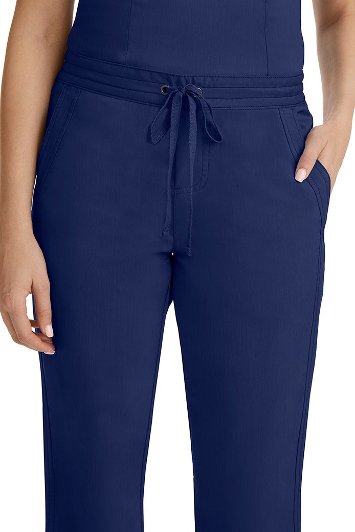 A female healthcare professional wearing a Purple Label Women's Taylor Drawstring Scrub Pant in Navy featuring triple needle stitching throughout.