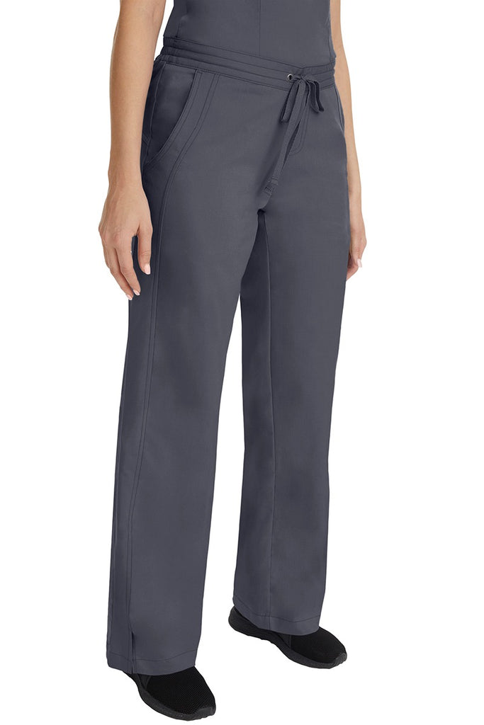 A young female RN wearing the Purple Label Women's Taylor Drawstring Scrub Pant in Pewter  featuring side slits at the ankle for easy slip-on or removal.