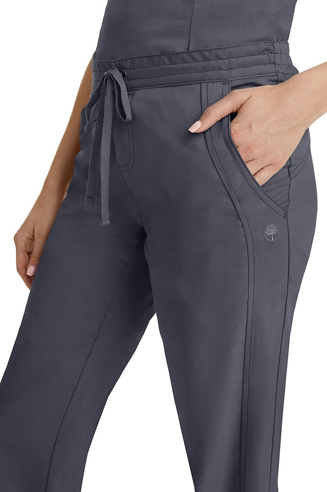 A young woman wearing a pair of Purple Label Women's Taylor Drawstring Scrub Pants from Healing Hands in Pewter. Perfect for Healthcare Professionals working in Hospitals, Doctors offices, Dental Groups & Veterinary offices!