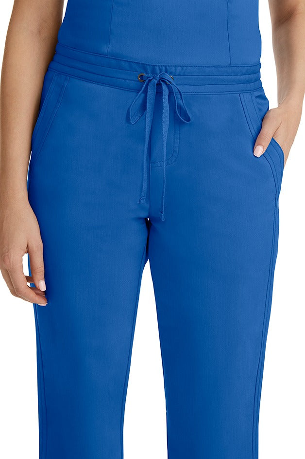 A female healthcare professional wearing a Purple Label Women's Taylor Drawstring Scrub Pant in Royal featuring triple needle stitching throughout.