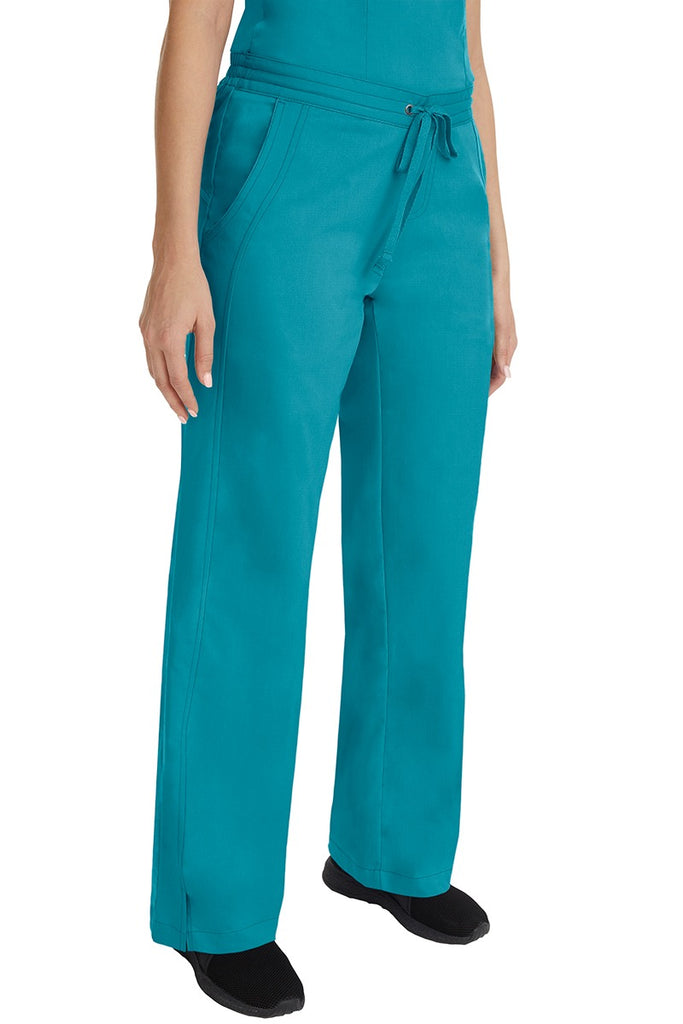 A young female RN wearing the Purple Label Women's Taylor Drawstring Scrub Pant in Teal featuring side slits at the ankle for easy slip-on or removal.