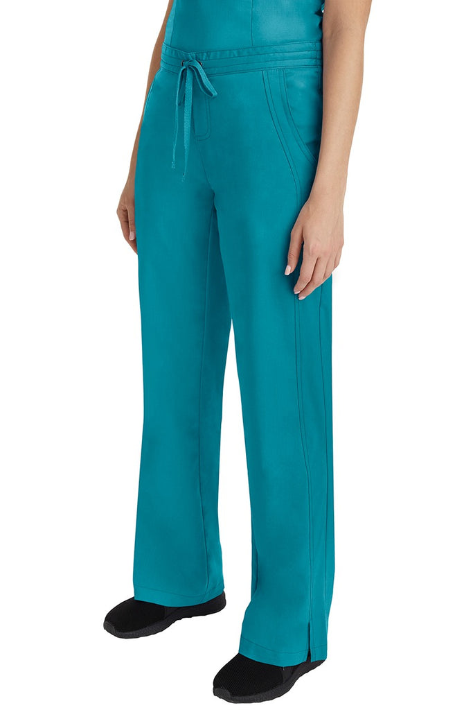 A young Home Care Registered Nurse wearing a Purple Label Women's Taylor Drawstring Scrub Pant in Teal featuring front wrap seaming detail throughout.