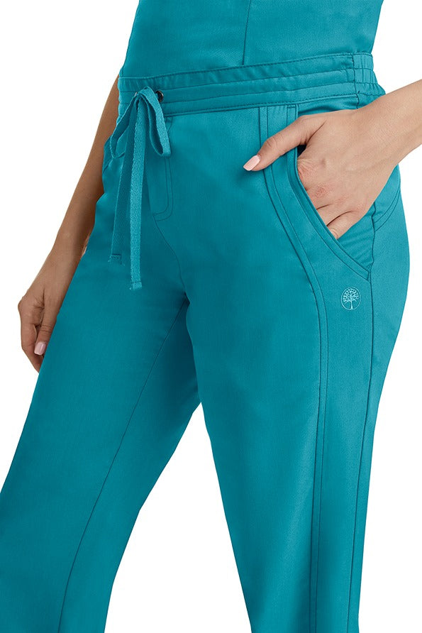 A young woman wearing a pair of Purple Label Women's Taylor Drawstring Scrub Pants from Healing Hands in Teal. Perfect for Healthcare Professionals working in Hospitals, Doctors offices, Dental Groups & Veterinary offices!