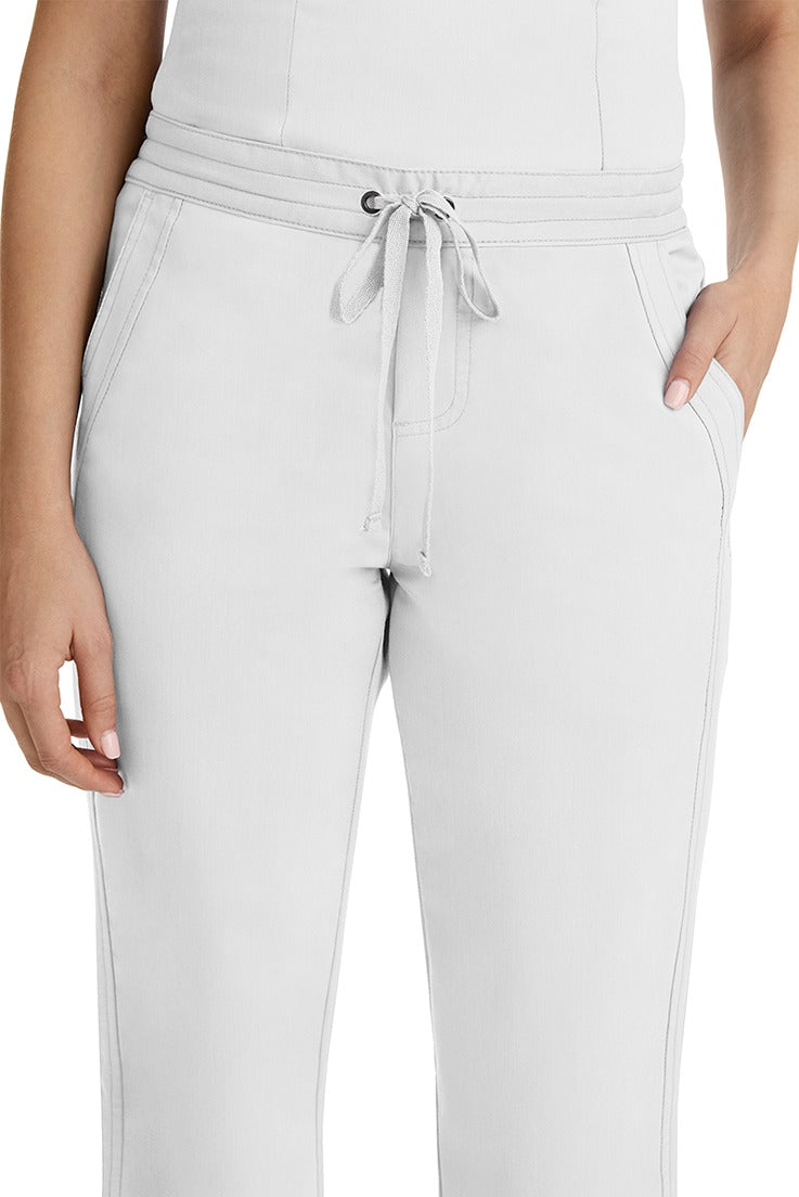 A female healthcare professional wearing a Purple Label Women's Taylor Drawstring Scrub Pant in White featuring triple needle stitching throughout.