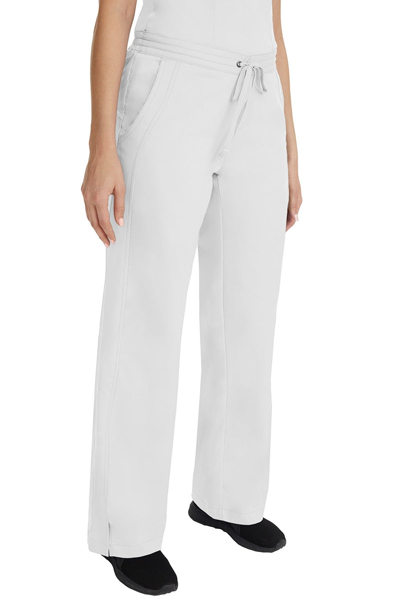 A young female RN wearing the Purple Label Women's Taylor Drawstring Scrub Pant in White featuring side slits at the ankle for easy slip-on or removal.
