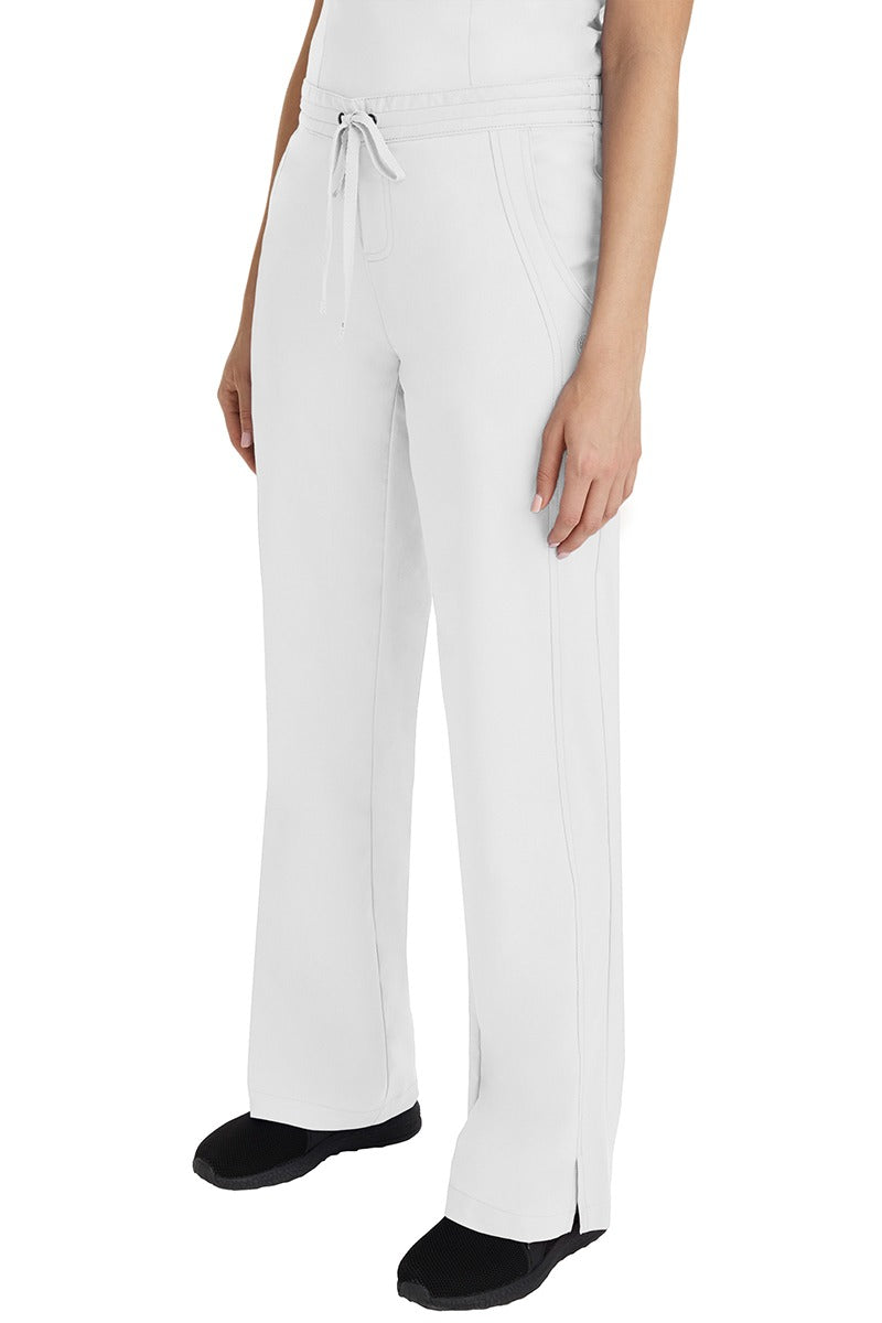 A young Home Care Registered Nurse wearing a Purple Label Women's Taylor Drawstring Scrub Pant in White featuring front wrap seaming detail throughout.