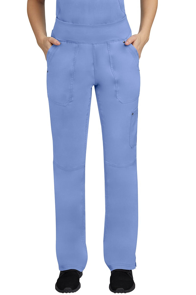 A young female LPN wearing a Purple Label Women's Tori Yoga Waistband Scrub Pant in Ceil featuring 2 front side-entry pockets with grommet details.