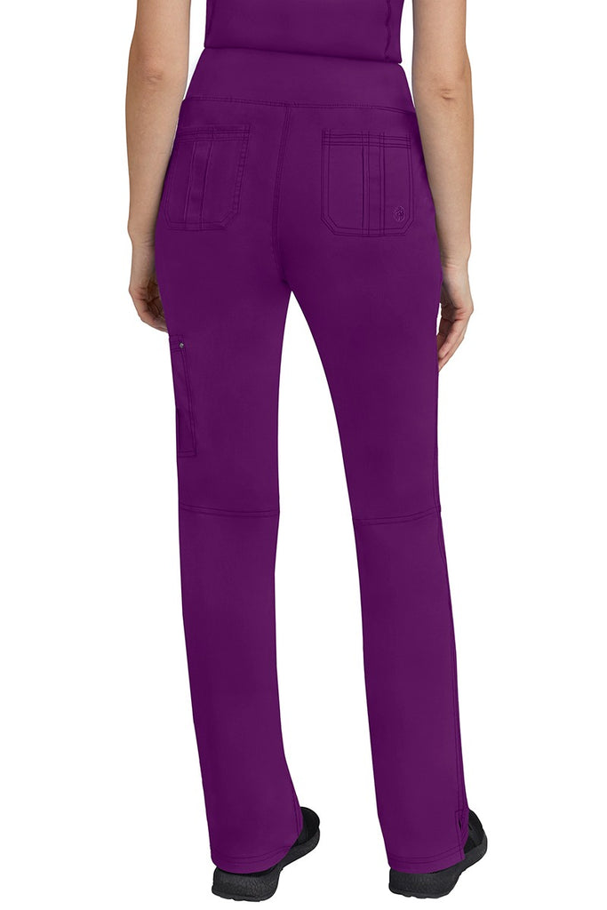 A lady CNA wearing a pair of Women's Tori Yoga Waistband Scrub Pants from Purple Label in Eggplant featuring 2 back patch pockets for additional on the job storage room.