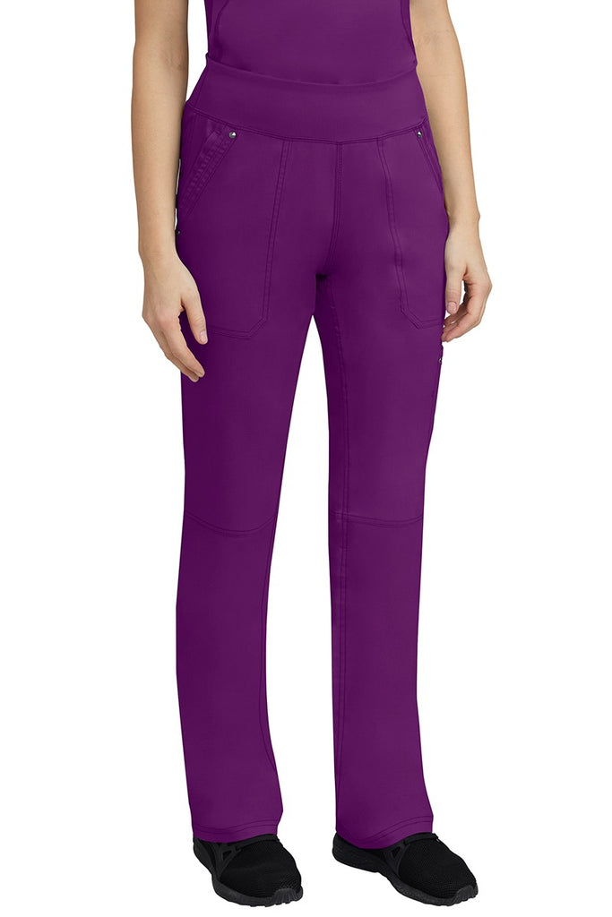 A young woman wearing a Purple Label Women's Tori Yoga Waistband Scrub Pant in Eggplant featuring a yoga knit waistband.