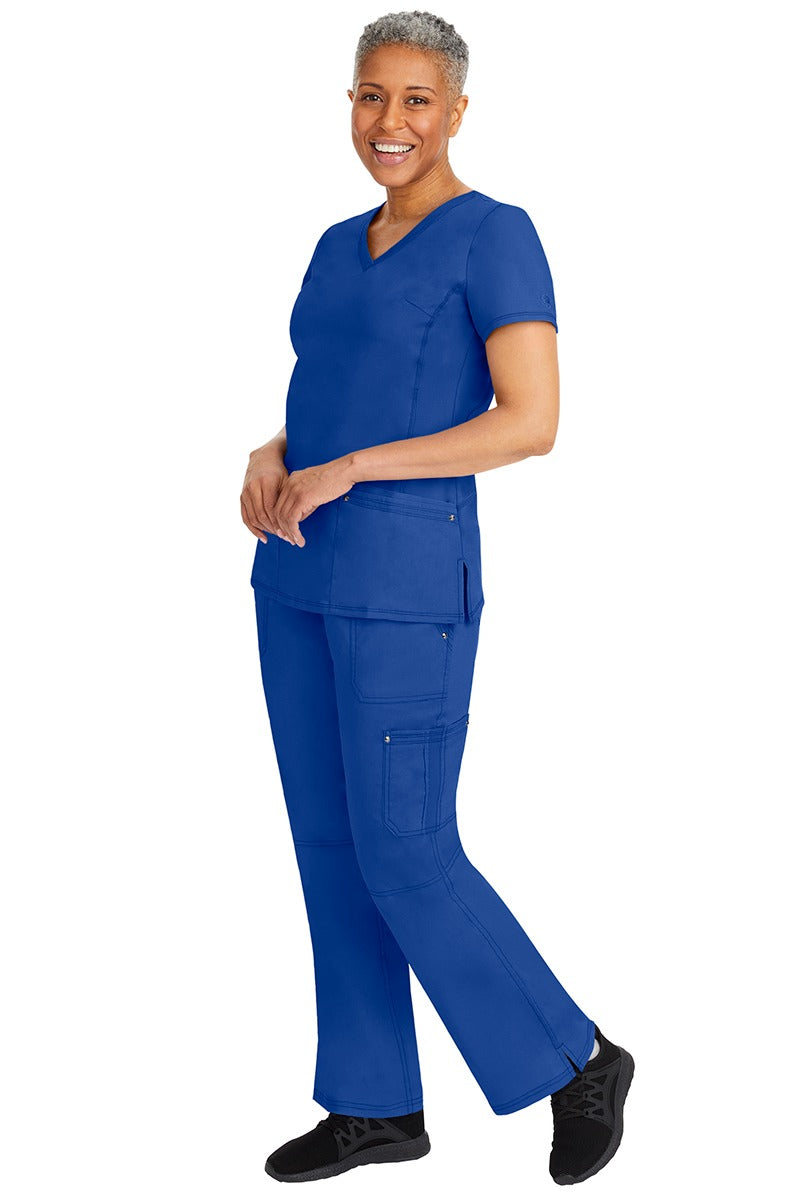 A young female nurse wearing a pair of Purple Label Women's Tori Yoga Waistband Scrub Pants from Healing Hands in Galaxy Blue featuring a modern fit.