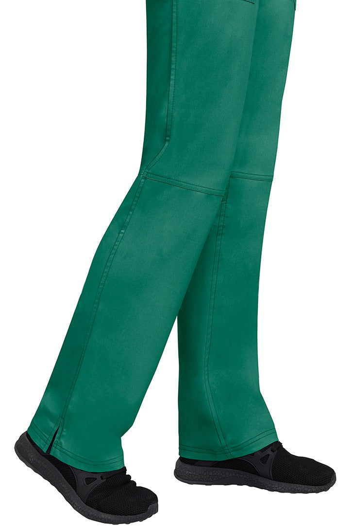 A young woman wearing a pair of Purple Label Women's Tori Yoga Waistband Scrub Pants in Hunter Green featuring a fabric made of 77% Polyester/ 20% Rayon/ 3% Spandex.