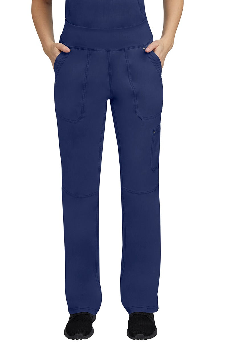 A young female LPN wearing a Purple Label Women's Tori Yoga Waistband Scrub Pant in Navy featuring 2 front side-entry pockets with grommet details.