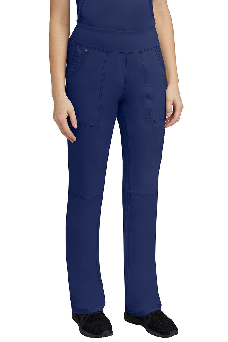 A young woman wearing a Purple Label Women's Tori Yoga Waistband Scrub Pant in Navy featuring a yoga knit waistband.