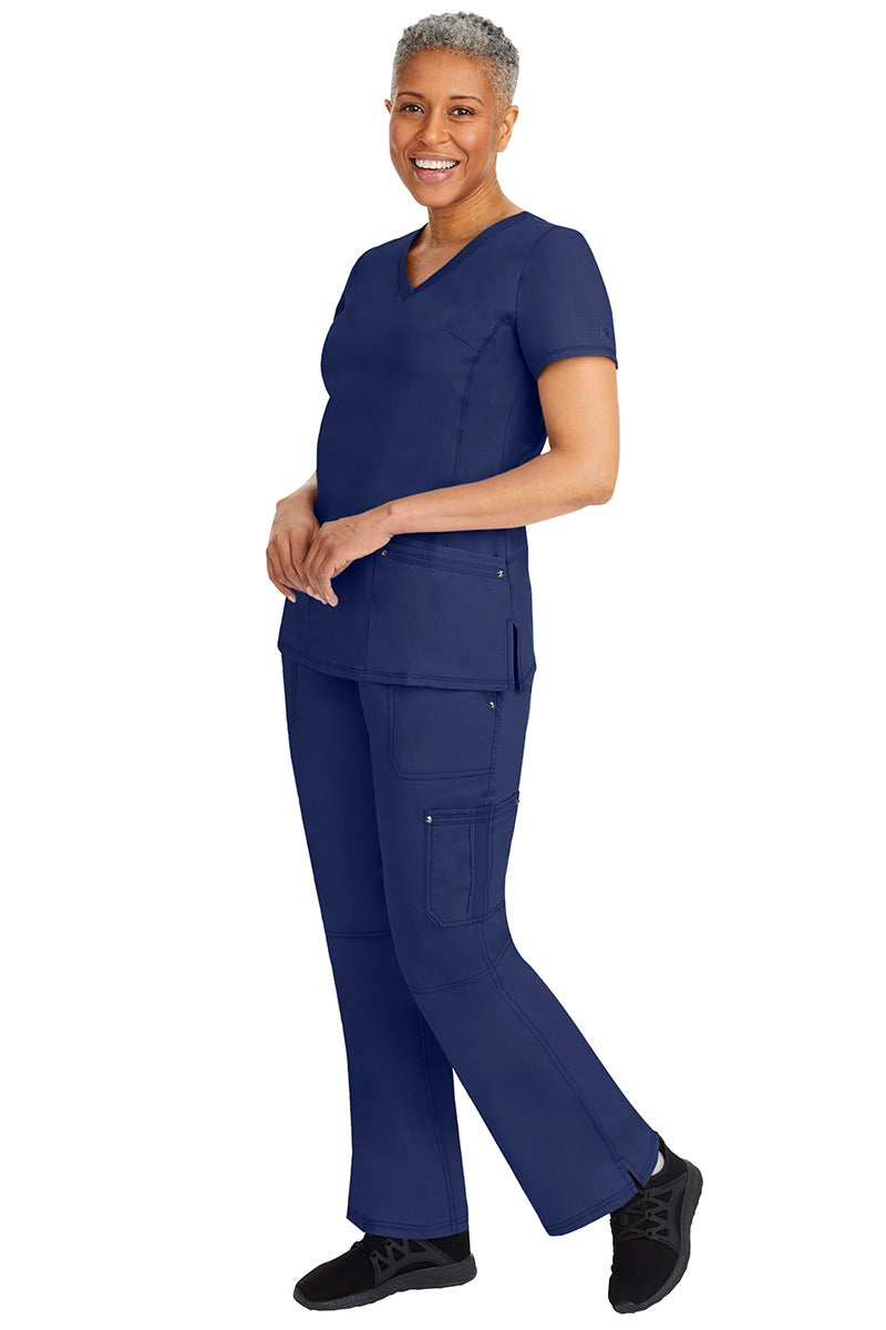 A young female nurse wearing a pair of Purple Label Women's Tori Yoga Waistband Scrub Pants from Healing Hands in Navy featuring a modern fit.