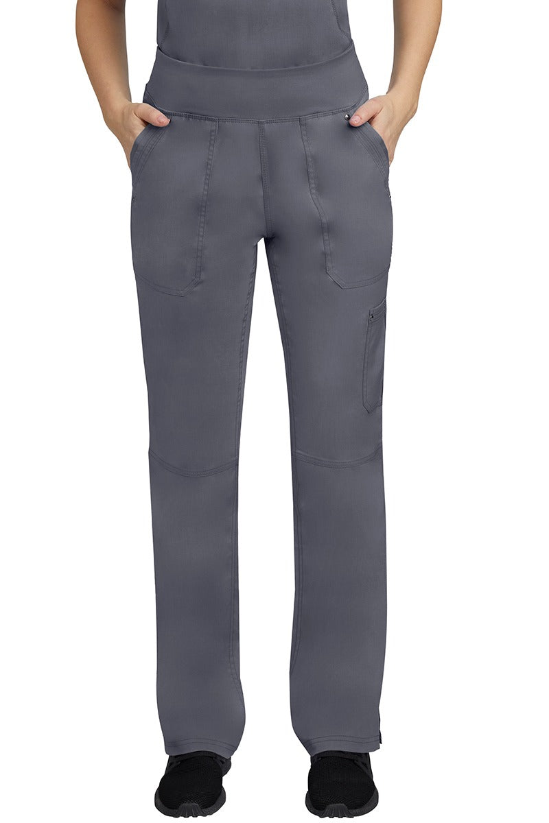 A young female LPN wearing a Purple Label Women's Tori Yoga Waistband Scrub Pant in Pewter featuring 2 front side-entry pockets with grommet details.