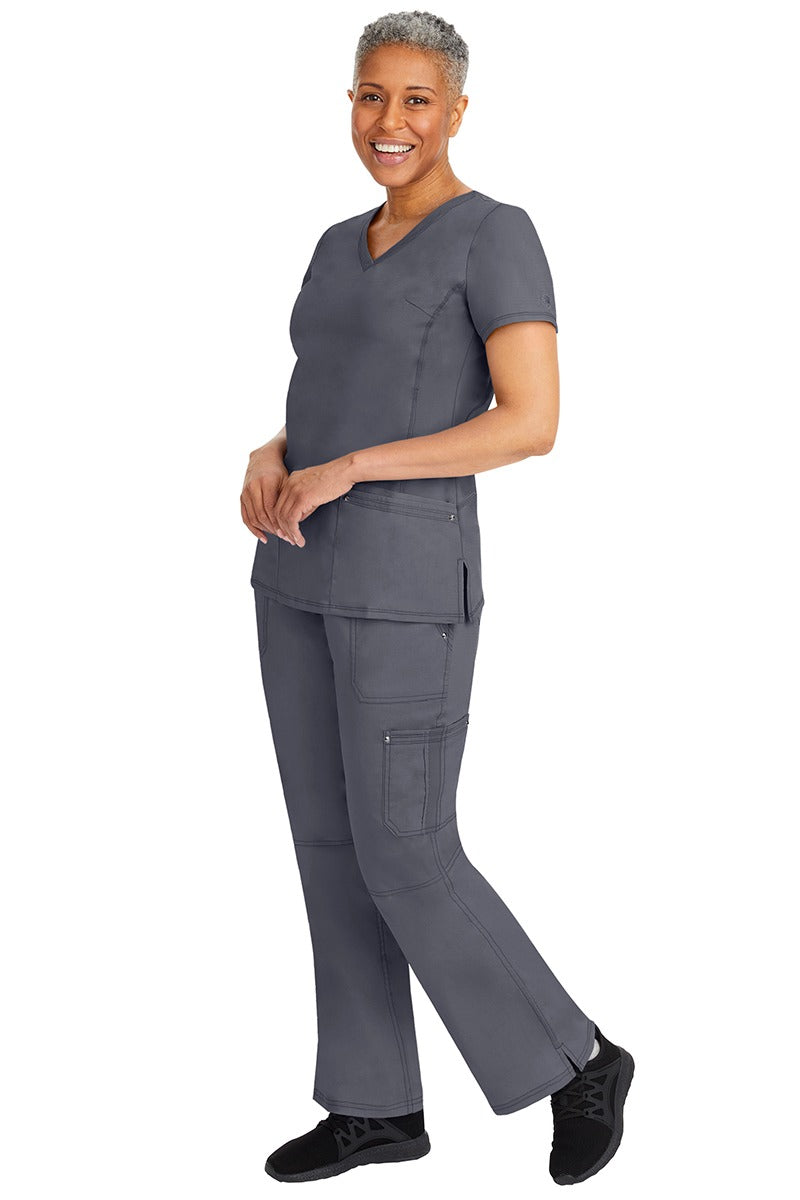 A young female nurse wearing a pair of Purple Label Women's Tori Yoga Waistband Scrub Pants from Healing Hands in Pewter featuring a modern fit.