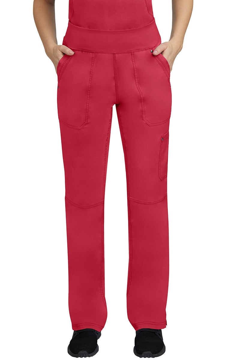 A young female LPN wearing a Purple Label Women's Tori Yoga Waistband Scrub Pant in Red featuring 2 front side-entry pockets with grommet details.