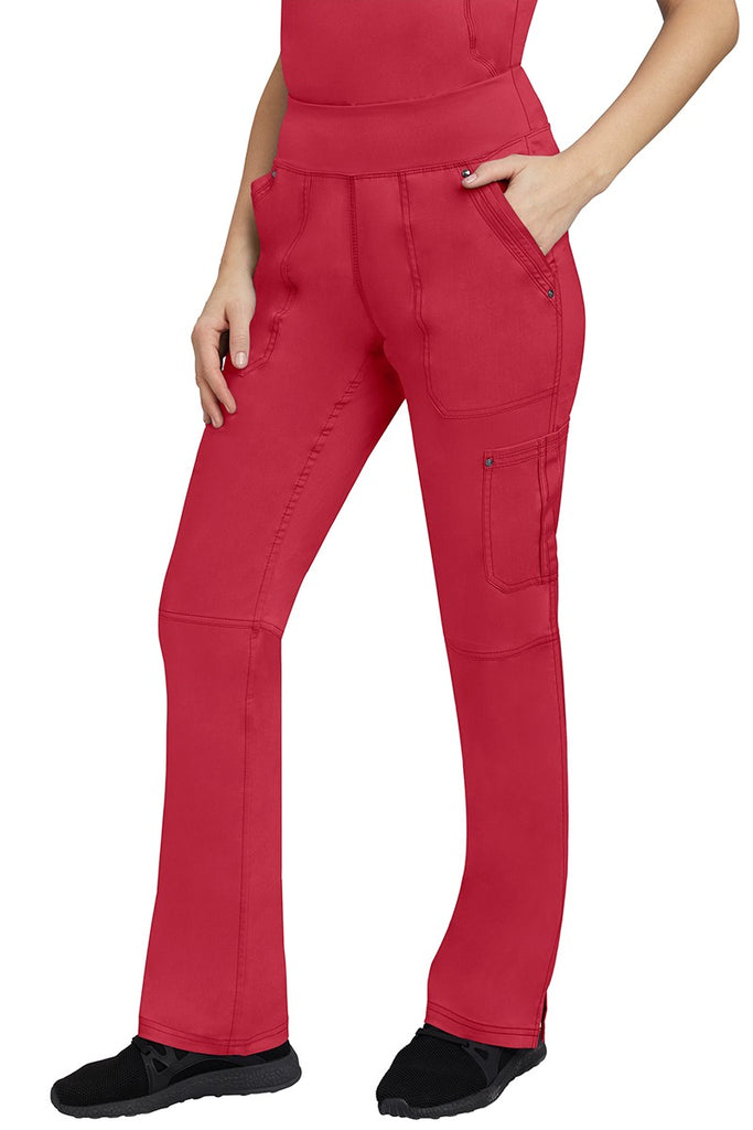 A young Home Care Registered Nurse wearing a pair of Purple Label Women's Tori Yoga Waistband Scrub Pants in Red featuring 1 outer cargo pocket on the wearer's left side pant leg.