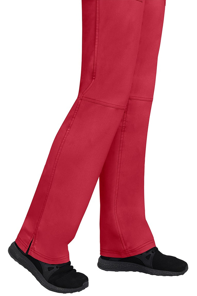 A young woman wearing a pair of Purple Label Women's Tori Yoga Waistband Scrub Pants in Red featuring a fabric made of 77% Polyester/ 20% Rayon/ 3% Spandex.