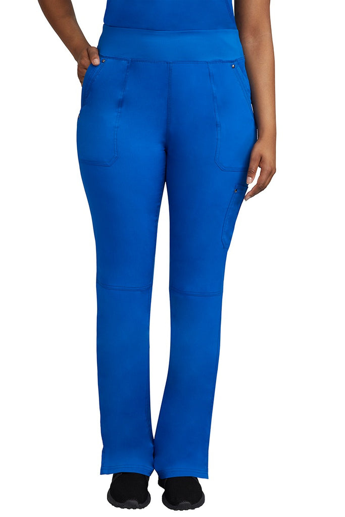 A young female LPN wearing a Purple Label Women's Tori Yoga Waistband Scrub Pant in Royal featuring 2 front side-entry pockets with grommet details.