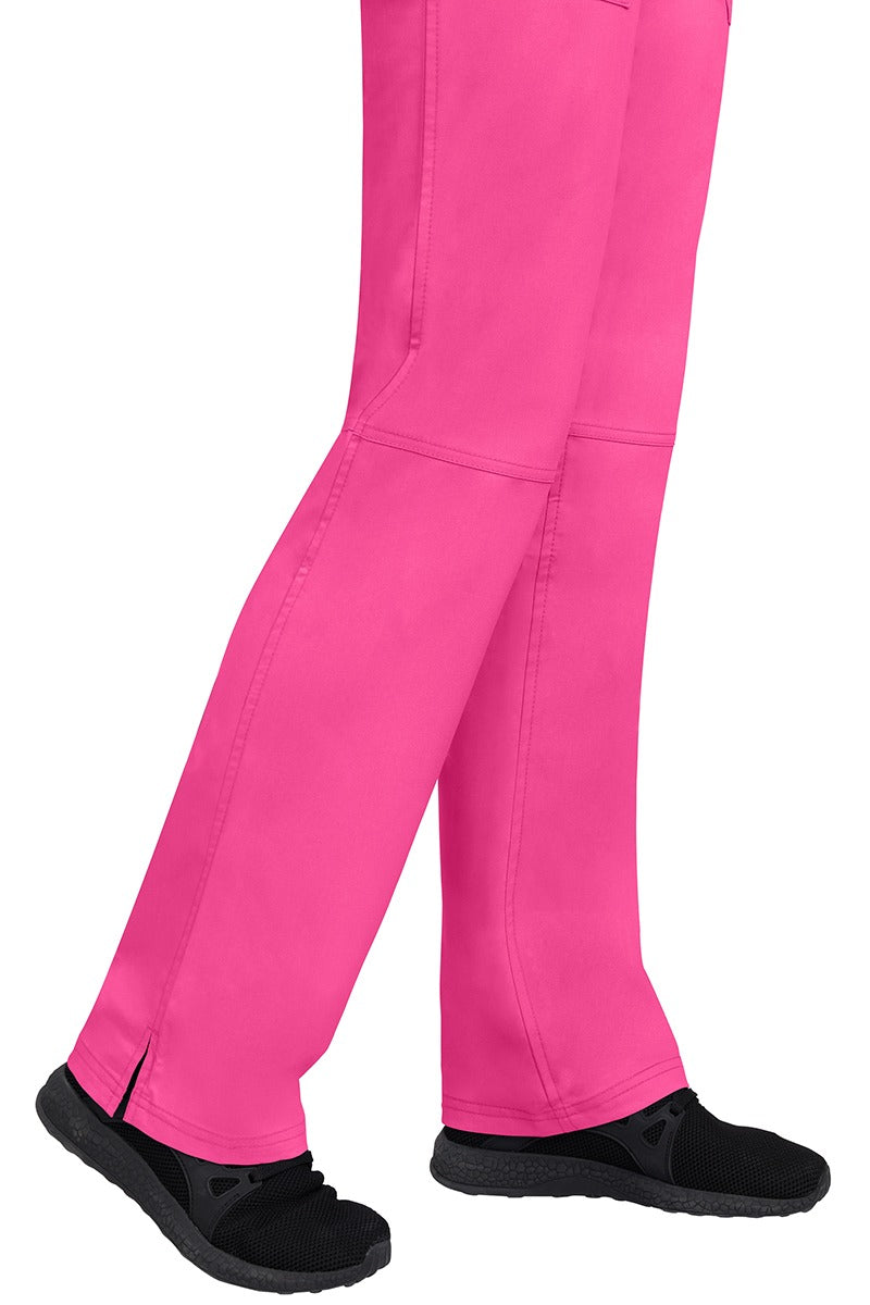 A young woman wearing a pair of Purple Label Women's Tori Yoga Waistband Scrub Pants in Shocking Pink featuring a fabric made of 77% Polyester/ 20% Rayon/ 3% Spandex.