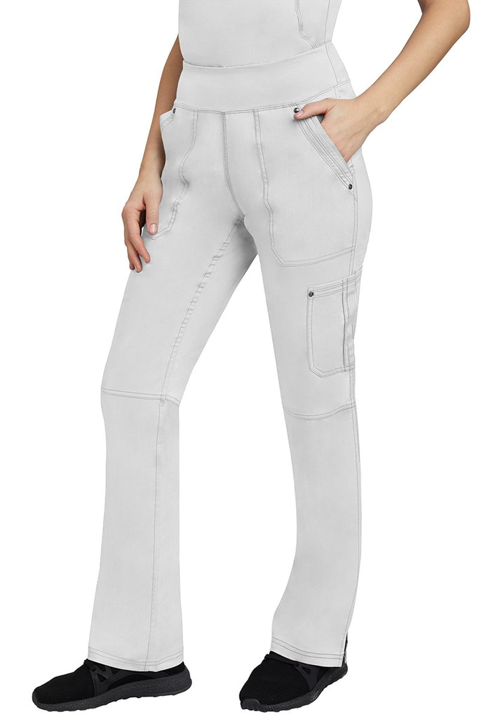 A young Home Care Registered Nurse wearing a pair of Purple Label Women's Tori Yoga Waistband Scrub Pants in White featuring 1 outer cargo pocket on the wearer's left side pant leg.