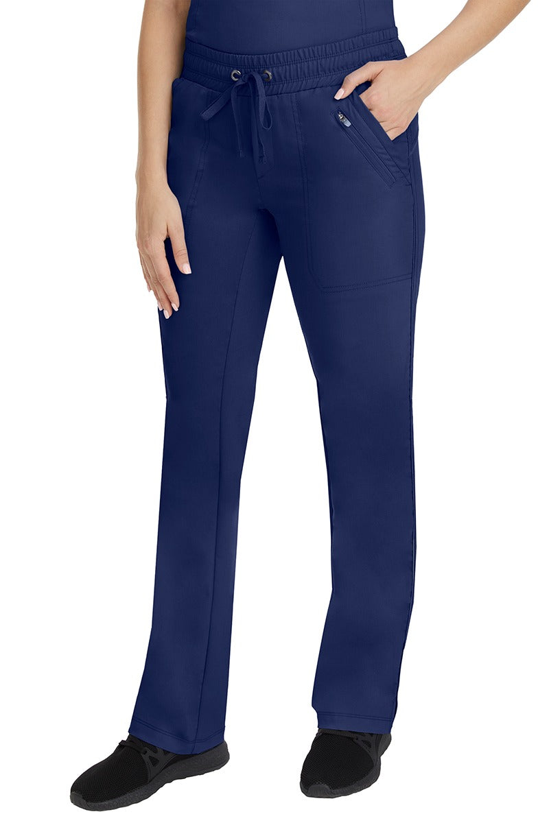 A young Home Care Registered Nurse wearing a pair of Purple Label Women's Tanya Drawstring Cargo Scrub Pant in Navy featuring 2 front slash pockets.