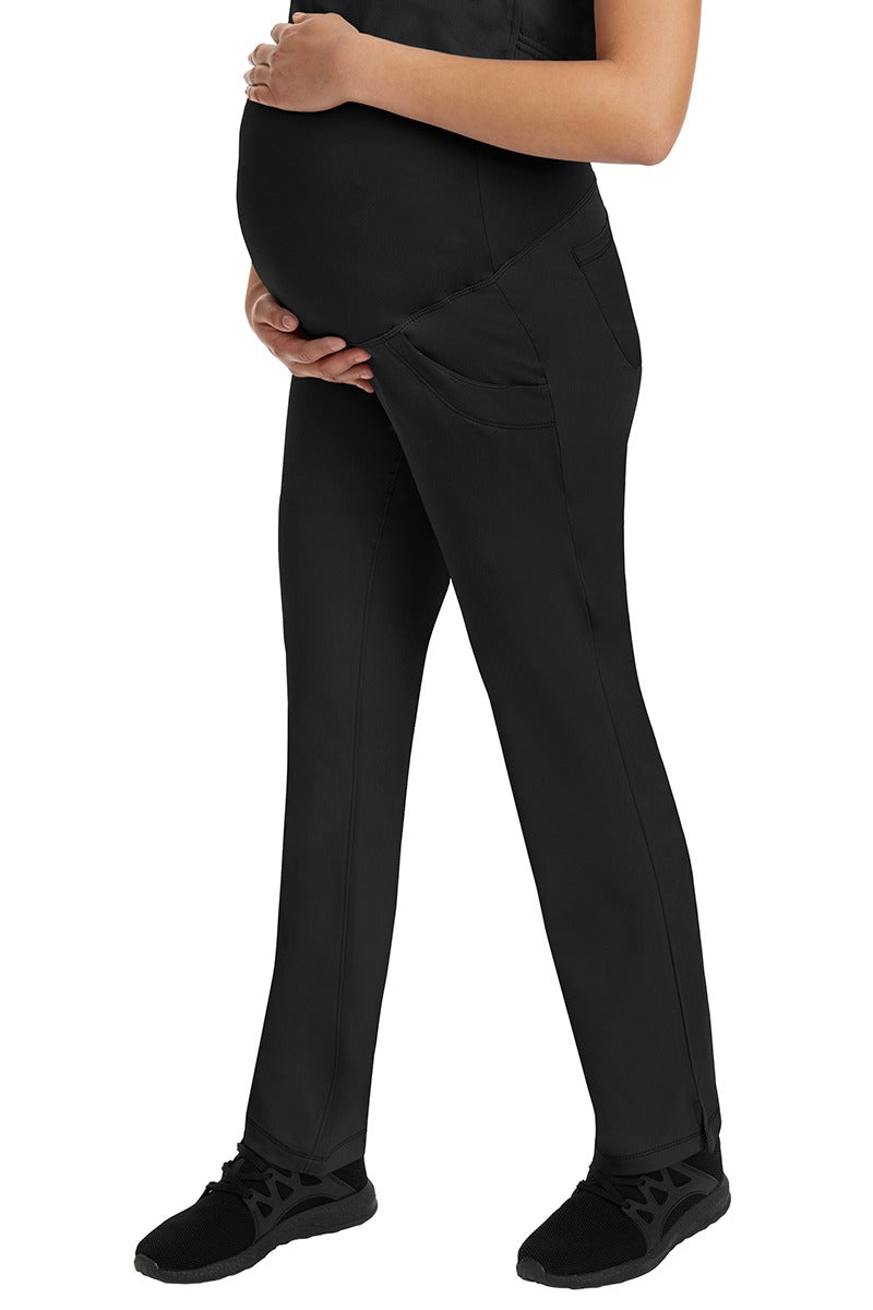 A female Home Care Registered Nurse wearing an HH-Works Women's Rose Maternity Cargo Scrub Pant in Black featuring side slits for additional mobility. 