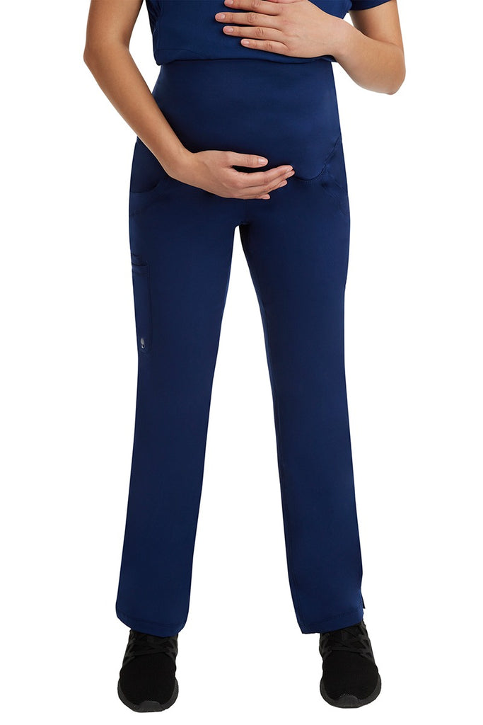 A young female LPN wearing an HH-Works Women's Rose Maternity Cargo Scrub Pant in Navy featuring a stretch yoga waistband.