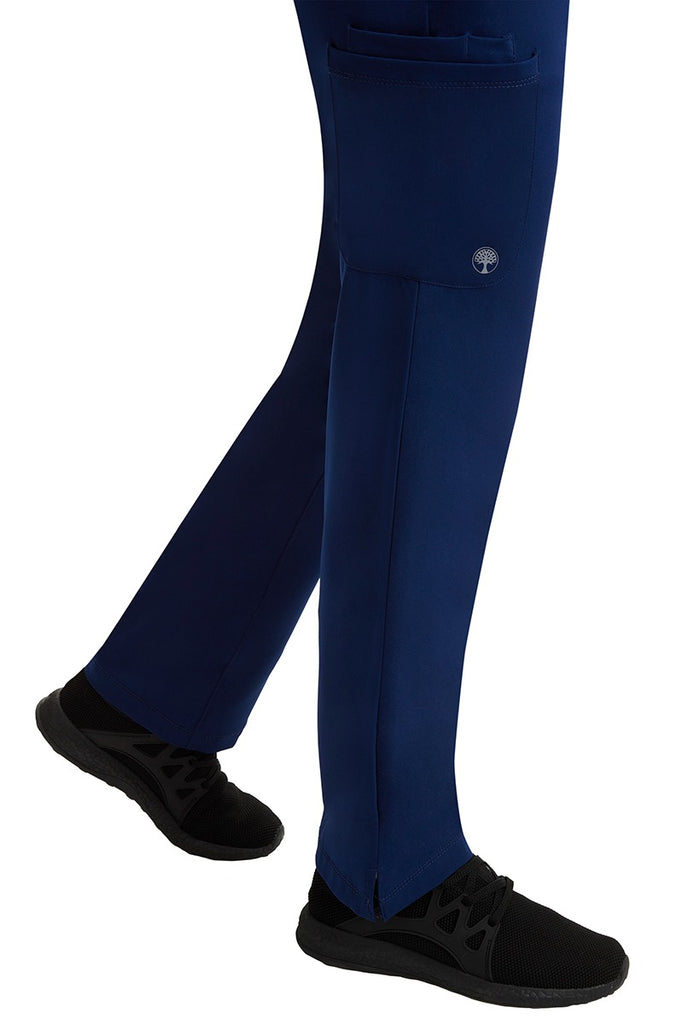 A young female healthcare professional wearing an HH-Works Women's Rose Maternity Cargo Scrub Pant in Navy featuring a super comfortable stretch fabric made of 91% polyester & 9% spandex.
