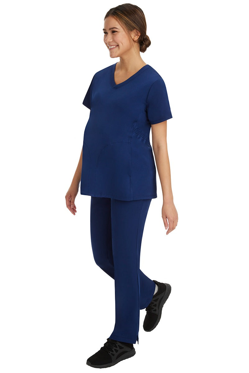 A pregnant CNA wearing a Women's Rose Maternity Cargo Scrub Pant from HH Works in Navy featuring a a high rise, straight leg pant.