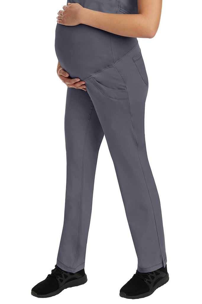 A female Home Care Registered Nurse wearing an HH-Works Women's Rose Maternity Cargo Scrub Pant in Pewter featuring side slits for additional mobility.