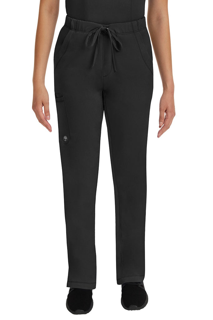 A young lady LPN wearing an HH Works Women's Rebecca Multi-Pocket Drawstring Pant in Black featuring n all elastic waistband with a drawstring tie front.