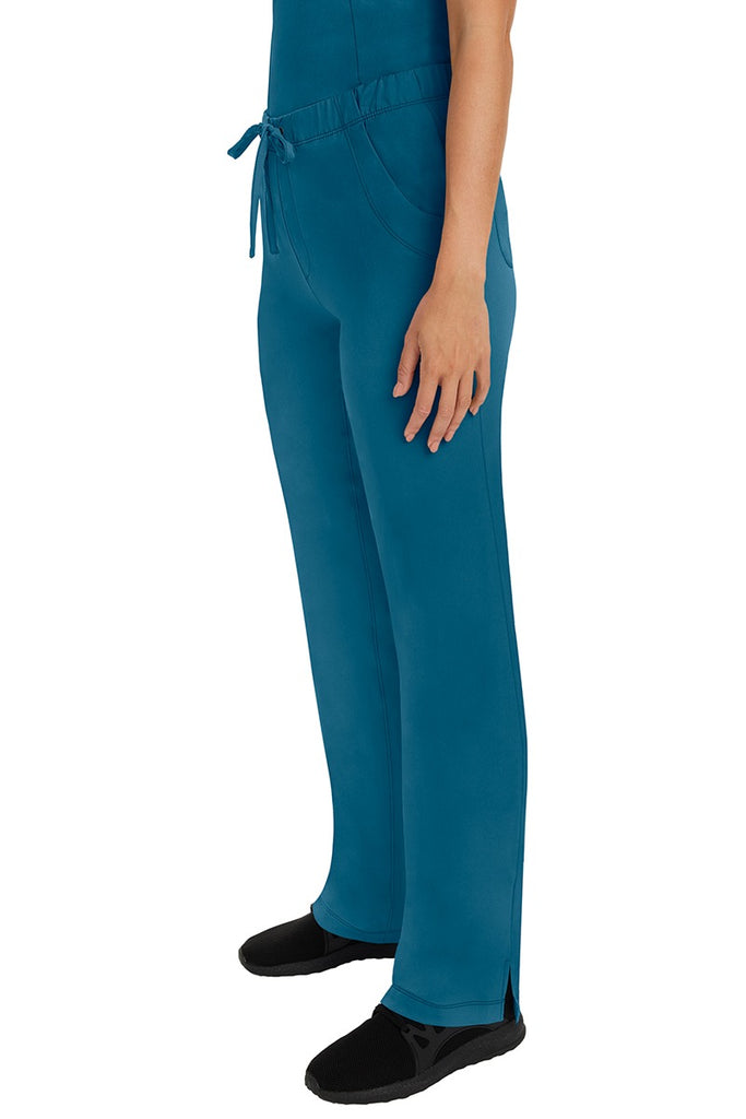 A woman Home Care Registered Nurse wearing a pair of HH-Works Women's Rebecca Multi-Pocket Drawstring Pants in Caribbean featuring side slits for additional range of motion.