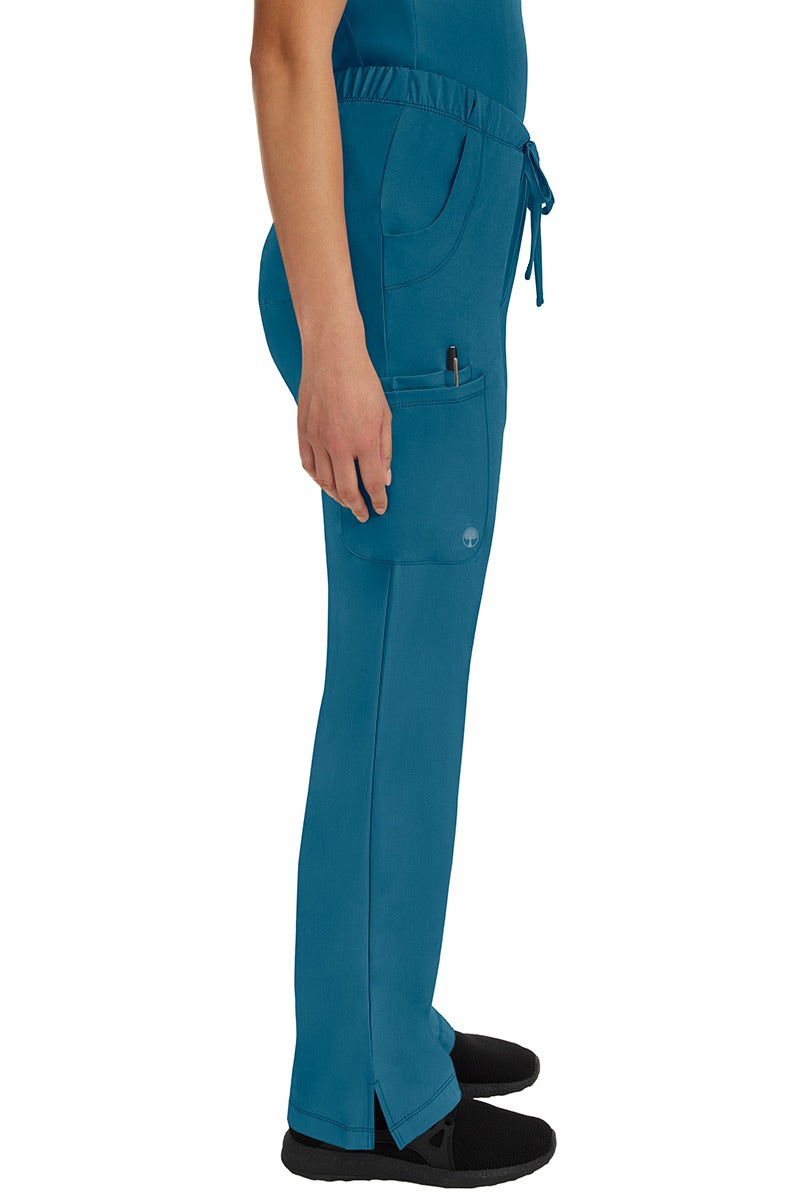 A young woman wearing an HH-Works Women's Rebecca Multi-Pocket Drawstring Pant in Caribbean featuring a super comfortable stretch fabric made of 91% polyester & 9% spandex.
