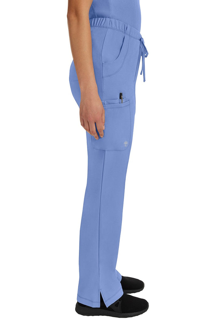 A young woman wearing an HH-Works Women's Rebecca Multi-Pocket Drawstring Pant in Ceil featuring a super comfortable stretch fabric made of 91% polyester & 9% spandex.