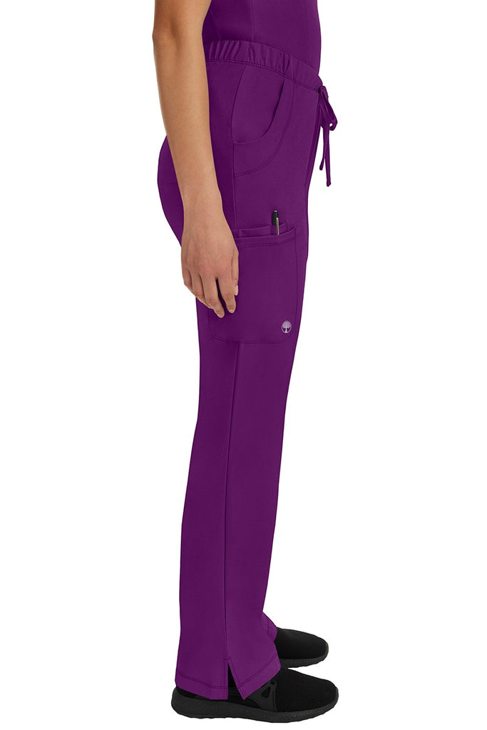 A young woman wearing an HH-Works Women's Rebecca Multi-Pocket Drawstring Pant in Eggplant featuring a super comfortable stretch fabric made of 91% polyester & 9% spandex.