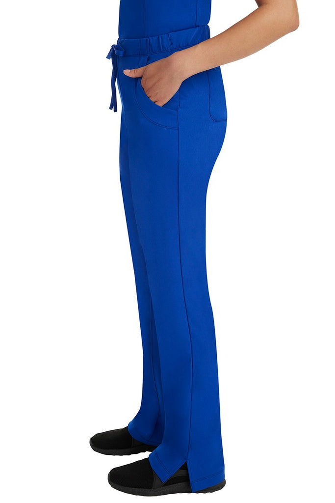 A woman Home Care Registered Nurse wearing a pair of HH-Works Women's Rebecca Multi-Pocket Drawstring Pants in Galaxy Blue featuring side slits for additional range of motion.